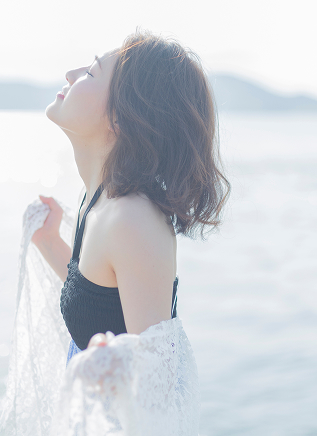 海辺で深呼吸する女性