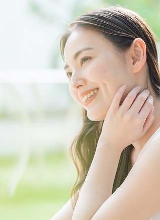 肌に触れて微笑む女性